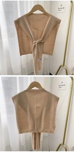 Detailed knit shawl close-up showing fine ribbed edges and tie-front strap in beige