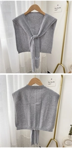 Detail of grey knitted cashmere shawl with cross-tie design for autumn layering
