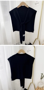Close-up of black knitted shawl accessory with ties on a golden hanger detail