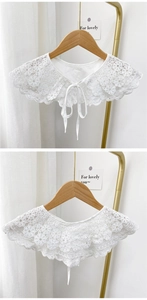 Close-up of elegant white lace false collar with delicate floral embroidery and ribbon tie