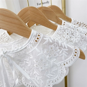 White lace hollow embroidered shawl collar with ribbon tie displayed on wooden hangers