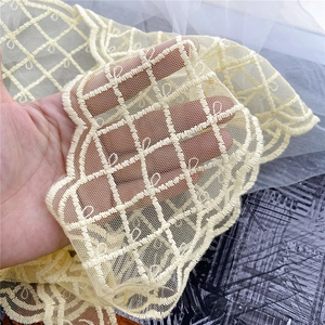 Detailed close-up of yellow lattice lace fabric with delicate embroidery for hair scarf