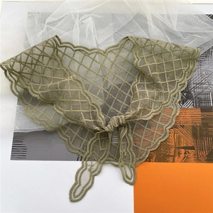 Close-up of olive green lace scarf showing delicate mesh embroidery and scalloped edges