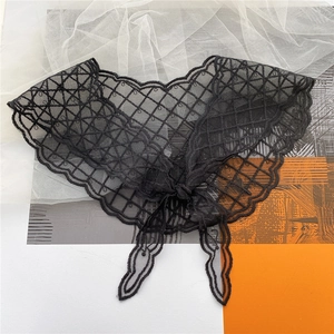 Detailed macro view of black lace triangular scarf with diamond embroidery and wave edges