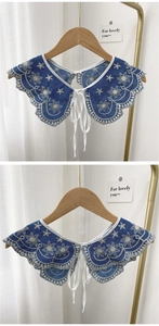 Detail of blue denim collar with white floral embroidery and lace trim on wooden hanger
