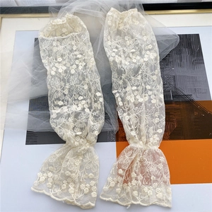 Close-up of floral lace sleeve covers with delicate embroidery and ruffled edges