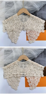 Detail of crochet floral lace shawl with scalloped edges and pearl button closure