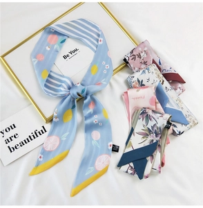 Close-up of lightweight silk scarves featuring lemon, peach, and floral prints