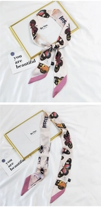 Detailed view of silk ribbon scarf featuring butterfly prints and pink contrast ends