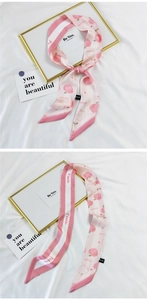 Detail view of pink peach print satin hair scarf with elegant peach patterns and branding