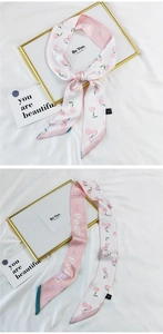 Detailed macro view of pink peach print silk twilly scarf for hair styling or bag accessory