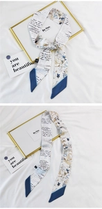 Detail of cream silk scarf with blue floral pattern and dark blue contrast ends