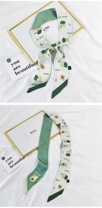Detail of avocado print silk-like narrow scarf with smooth satin finish and green tones