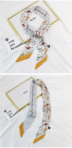 Detail of silk hair ribbon with floral butterfly patterns and yellow contrast borders