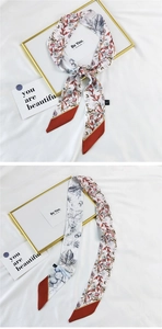 Close-up of double-sided floral silk twilly scarf with red-brown leaf patterns