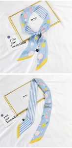 Detail of light blue silk scarf showing lemon prints and blue-white stripes with yellow edges