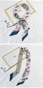 Detail of silk scarf with pink floral and dragonfly prints on white fabric