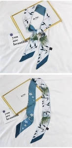 Detail of floral silk twilly scarf with blue and white pattern used as a versatile hair tie