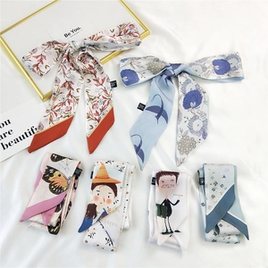 Elegant floral and butterfly print silk hair scarves displayed on white fabric background