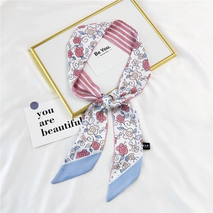 Pink floral and striped silk twilly hair scarf for women displayed on white fabric