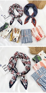 Close-up of pleated silk square scarves featuring colorful geometric and floral prints
