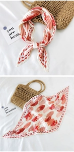 Detail of pleated silk scarf with red floral patterns and checkered border design