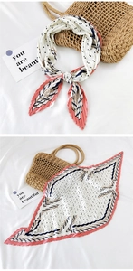Detail of pleated silk scarf with polka dots and geometric patterns on textured background