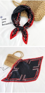Detail of pleated silk scarf featuring geometric polka dots and red accent pattern