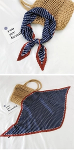 Detail of pleated silk scarf featuring navy stripes and a vibrant red border