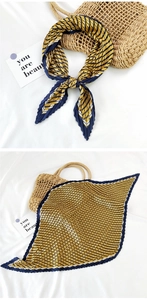 Detailed view of yellow and navy blue striped pleated silk scarf shown folded and tied