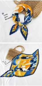 Detail of pleated square silk scarf with geometric pattern in yellow and blue colors