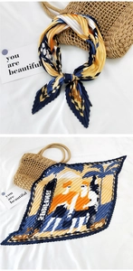 Detail of pleated silk scarf showing geometric patterns and abstract illustrations