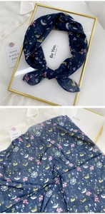 Detail showing the floral print texture and silky fabric of the navy blue small neck scarf