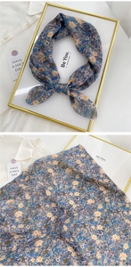 Detail of floral cotton linen scarf with delicate hem and pastel flower patterns