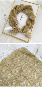 Close-up of yellow floral cotton linen scarf showing rolled edges and fabric texture