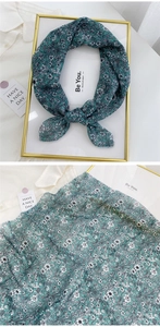 Detailed view of green floral cotton linen scarf displayed in a gold frame and flat lay