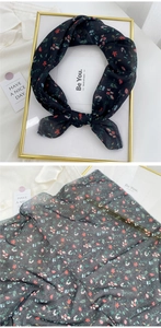 Close-up of lightweight black floral scarf with red and blue patterns on chiffon fabric