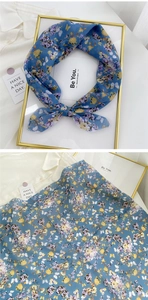 Detail of light blue floral cotton linen scarf with soft texture and floral print