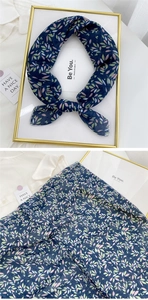 Detail of navy blue floral linen scarf with colorful leaf prints and machine-sewn edges