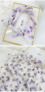 Close-up detail of floral cotton linen neckerchief with purple prints and soft texture