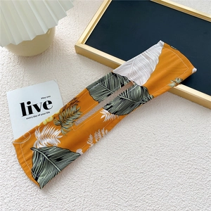 Macro shot of orange tropical leaf print hair deft bun maker with central slit detail