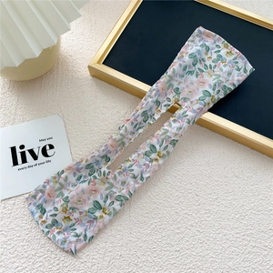 Floral fabric deft bun hair tool shown on a minimalist decorative tabletop setting