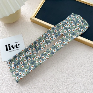 Floral print Deft Bun hair maker with white flower pattern on green fabric background