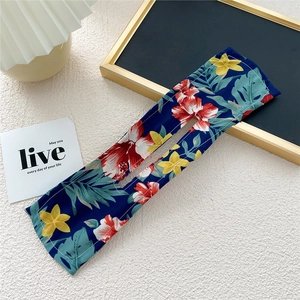 Detail of floral hair bun maker with tropical flower print on navy blue fabric
