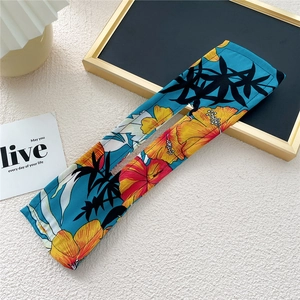 Close-up of fabric hair bun maker with vibrant tropical floral print on blue background