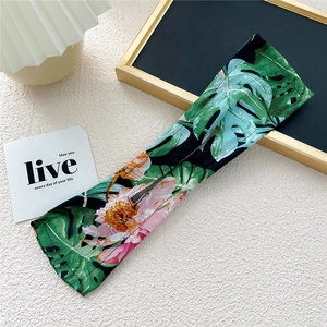 Close-up of fabric hair bun maker featuring tropical green leaves and pink floral patterns
