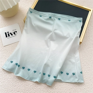 Détail du tissu en soie glacée vert clair avec motif de cœur et texture respirante
