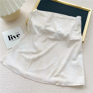 Détail d'extension de chemise blanche coupe trapèze avec texture tricotée et superposition