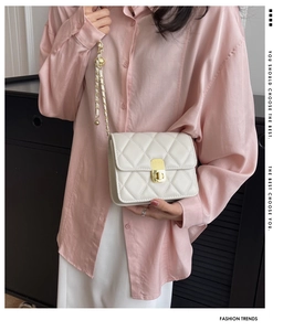 Chic quilted beige chain bag crossbody worn by a model in a casual stylish outfit