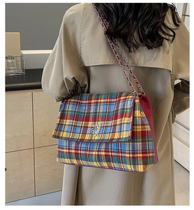 Detail of colorful plaid tweed shoulder bag with silver logo and metal chain strap
